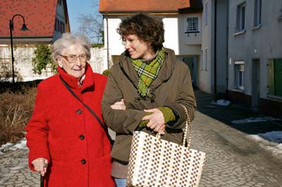 Bewegung bei Rheuma, Frau begleitet Seniorin