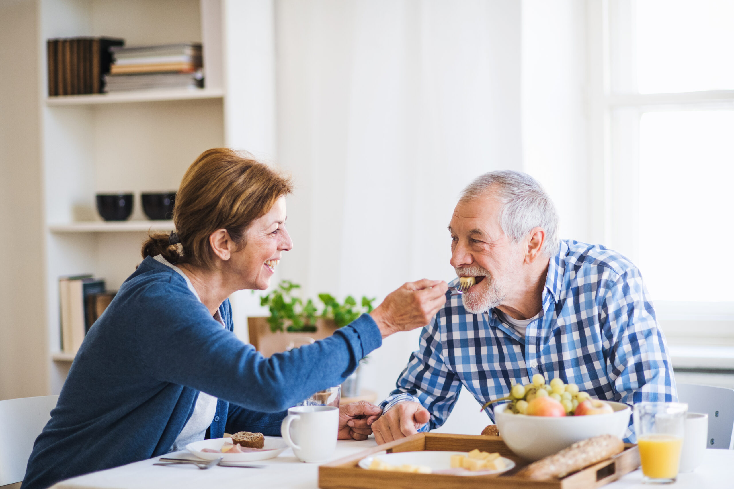 Ein glückliches Senioren-Paar am Frühstückstisch