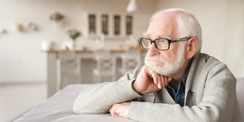 Depressiver alter Mann starrt in die Leere.